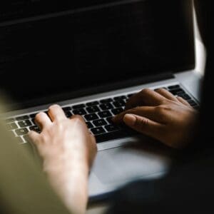 A person typing on a laptop computer.